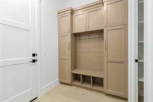 Mudroom with light wood finished floors and baseboards