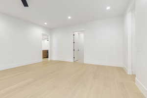 Empty room featuring light wood-type flooring and recessed lighting