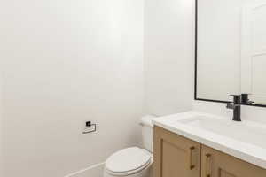 Half bathroom featuring vanity and toilet