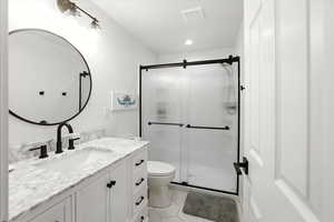 Full bathroom featuring vanity, a stall shower, light tile patterned floors, and recessed lighting