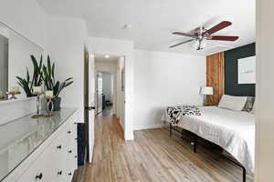 Bedroom with light wood-style floors and a ceiling fan