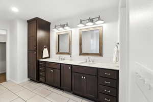 Full bathroom with double vanity and decorative backsplash