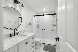 Full bathroom with vanity, a stall shower, light tile patterned flooring, and recessed lighting