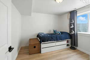 Bedroom with light wood-style floors and a textured ceiling