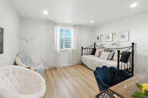 Bedroom with wood finished floors and recessed lighting