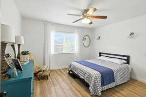 Bedroom with a ceiling fan and light wood-style floors
