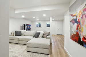 Living room with light wood-style flooring and recessed lighting