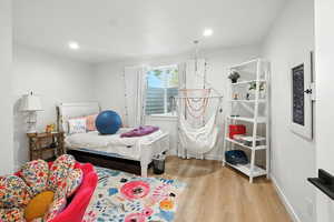 Bedroom with light wood-style floors and recessed lighting