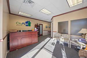 Reception featuring ornamental molding and a drop ceiling