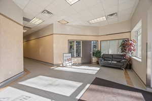 Common area featuring a paneled ceiling and a high ceiling
