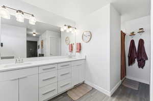 Bathroom with double vanity and baseboards