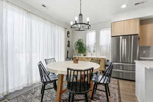 Dining space with dark wood-style floors, a chandelier, and recessed lighting
