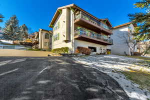Back of house featuring a balcony and stucco siding