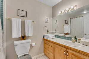 Bathroom featuring a shower with curtain, vanity, and light tile patterned floors