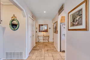 Hallway with stone tile flooring and recessed lighting