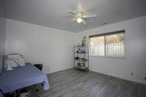 Bedroom with a ceiling fan, a textured ceiling, and an office area