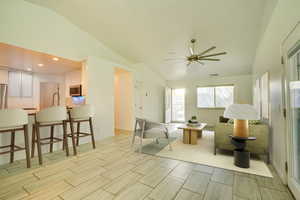 Living room featuring vaulted ceiling, tiled finish floors, ceiling fan, and recessed lighting