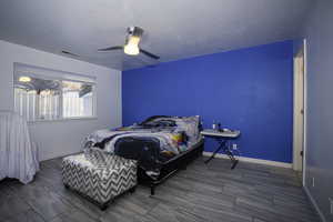 Bedroom featuring ceiling fan and a textured ceiling