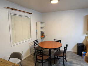 Dining space featuring dark wood-style flooring and baseboards