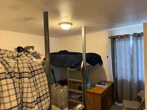 Bedroom featuring a textured ceiling and carpet