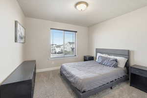 Bedroom featuring light carpet and baseboards
