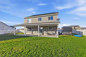 Rear view of house featuring a patio, solar panels, and a fenced backyard