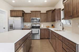 Kitchen with stainless steel appliances, light stone countertops, a kitchen island, light wood-type flooring, and recessed lighting