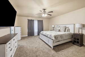 Bedroom featuring light carpet, a ceiling fan, and a textured ceiling
