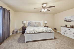 Bedroom with light colored carpet and a ceiling fan