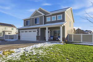 View of front of home featuring an attached garage, driveway, and a porch
