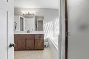 Full bath featuring vanity and a bath