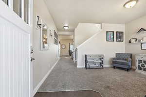 Carpeted foyer featuring baseboards