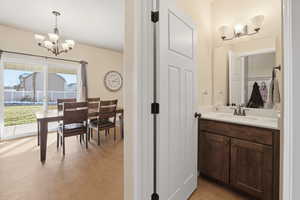 Bathroom featuring a chandelier, vanity, and light wood-type flooring