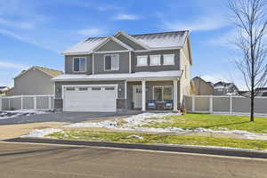 View of front of home featuring a porch, driveway, and an attached garage