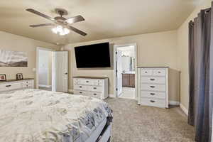 Bedroom featuring light carpet, a ceiling fan, and ensuite bathroom