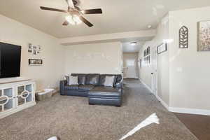 Living room featuring carpet and ceiling fan