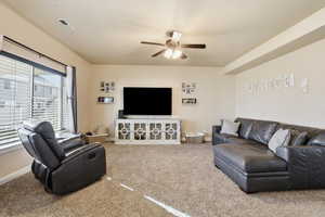 Living area featuring carpet flooring and ceiling fan