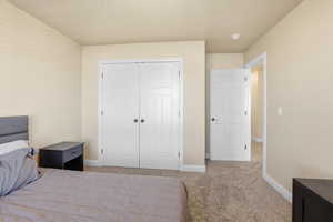 Bedroom featuring light colored carpet and a closet