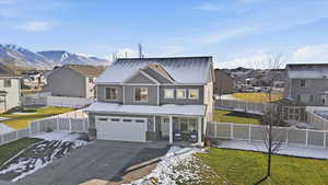 View of front of property featuring a residential view, a fenced backyard, driveway, and an attached garage