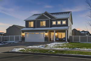 View of front of home featuring a porch, concrete driveway, and a garage