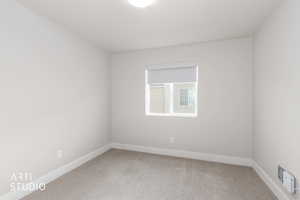 Empty room featuring light carpet and baseboards