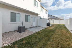 Rear view of property with stucco siding, a patio area, and a fenced backyard