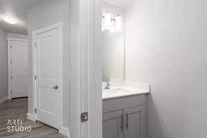 Half bathroom featuring vanity and wood finished floors