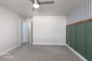 Unfurnished room with a textured ceiling, carpet, and a ceiling fan