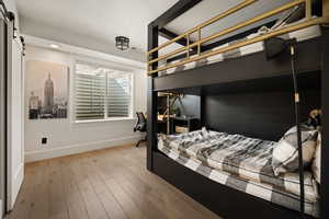 Bedroom featuring a barn door and hardwood / wood-style floors