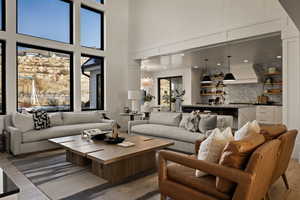 Living room featuring a chandelier, light wood finished floors, and a high ceiling