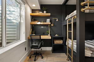 Home office with light wood-style flooring, plenty of natural light, built in study area, and recessed lighting