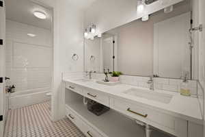 Bathroom featuring double vanity and bathtub / shower combination