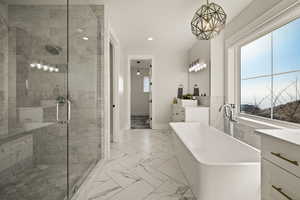 Bathroom with vanity, a freestanding bath, light marble finish floors, a stall shower, and recessed lighting