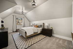 Bedroom featuring lofted ceiling, light carpet, and a textured ceiling